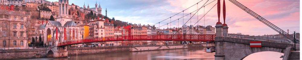 Vue du pont et des bâtiments colorés au bord de la rivière au coucher du soleil.