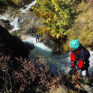 Canyoning enord avec casque bleu et harnais dans canyon.