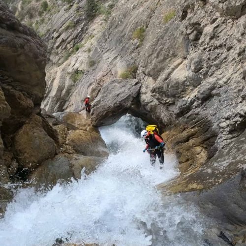 Randonneurs en canyoning dans une gorge étroite.